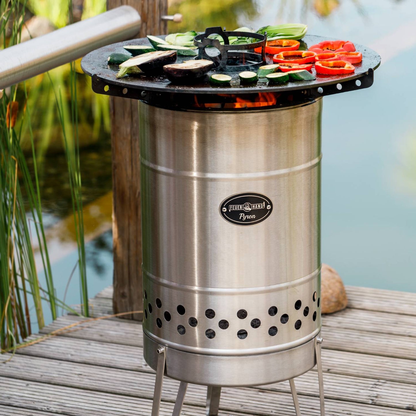 Stainless steel outdoor cooking device with a solid steel plate grilling colorful vegetables over open flames, perfect for Farm, Garden & Tool, Camping, Best Sellers, and Promo Eligible collections.