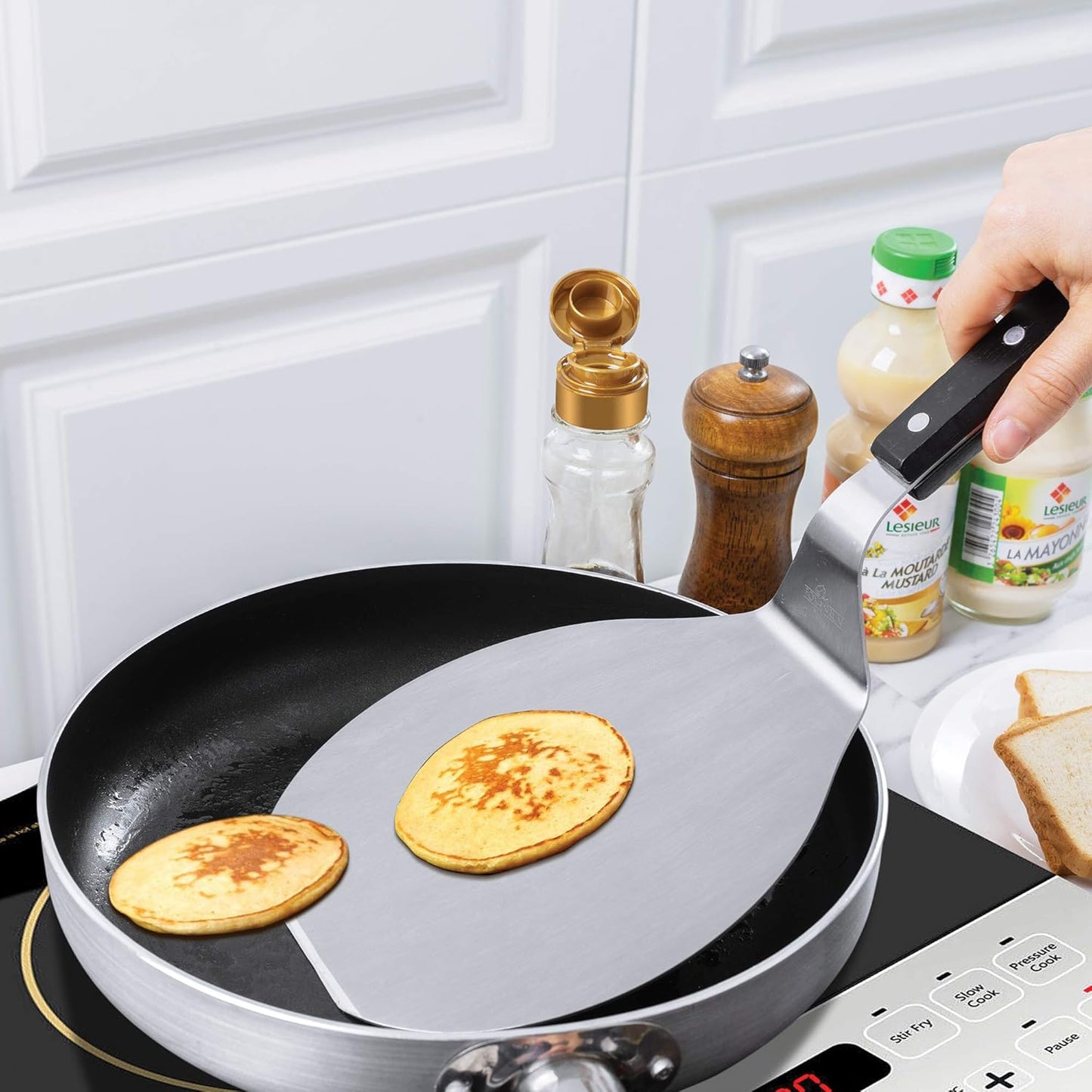 Wide stainless steel spatula with triple-riveted black handle lifting pancakes in a skillet, featured in Kitchen & Food, Kitchen Gadgets, Kitchen Accessories, Storage and Serving, Best Sellers, and Promo Eligible collections.
