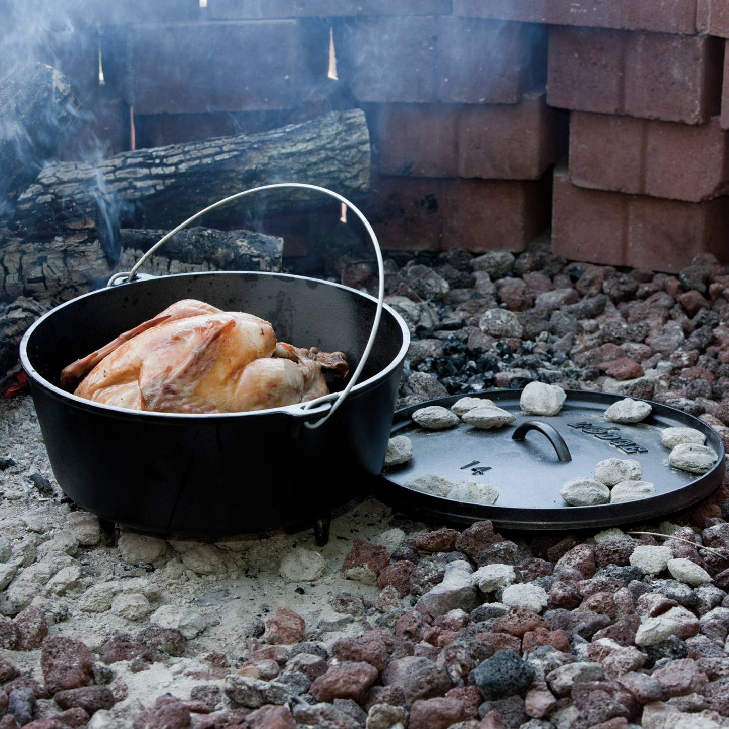 Handcrafted cast iron camp Dutch oven with built-in legs and metal bail handle roasting a whole chicken outdoors over coals; featured in Farm, Garden & Tool, Camping, Cast Iron, USA Made, Best Sellers, Promo Eligible collections.