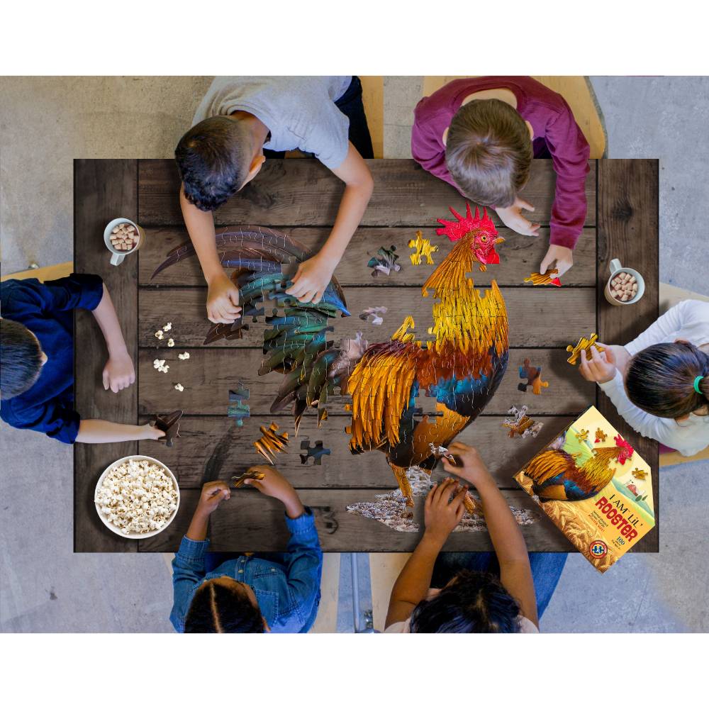 Children gathered around a wooden table assembling a uniquely shaped 100-piece rooster puzzle with large pieces, alongside snacks in a playful learning setting from toys and games collections.