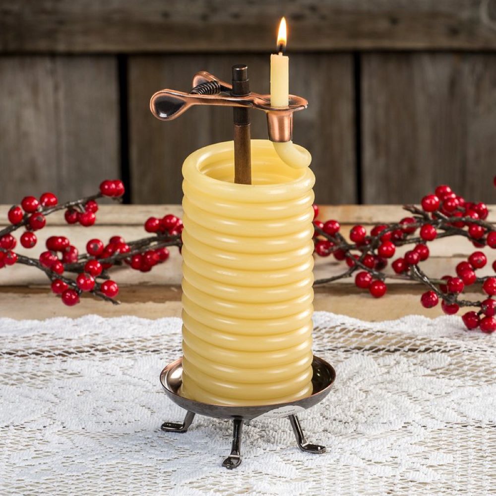 Coiled natural beeswax candle with a copper safety clip burning gently on a rustic metal stand, styled with red berries on a lace tablecloth, ideal for Lamps & Lighting and Candles collections.