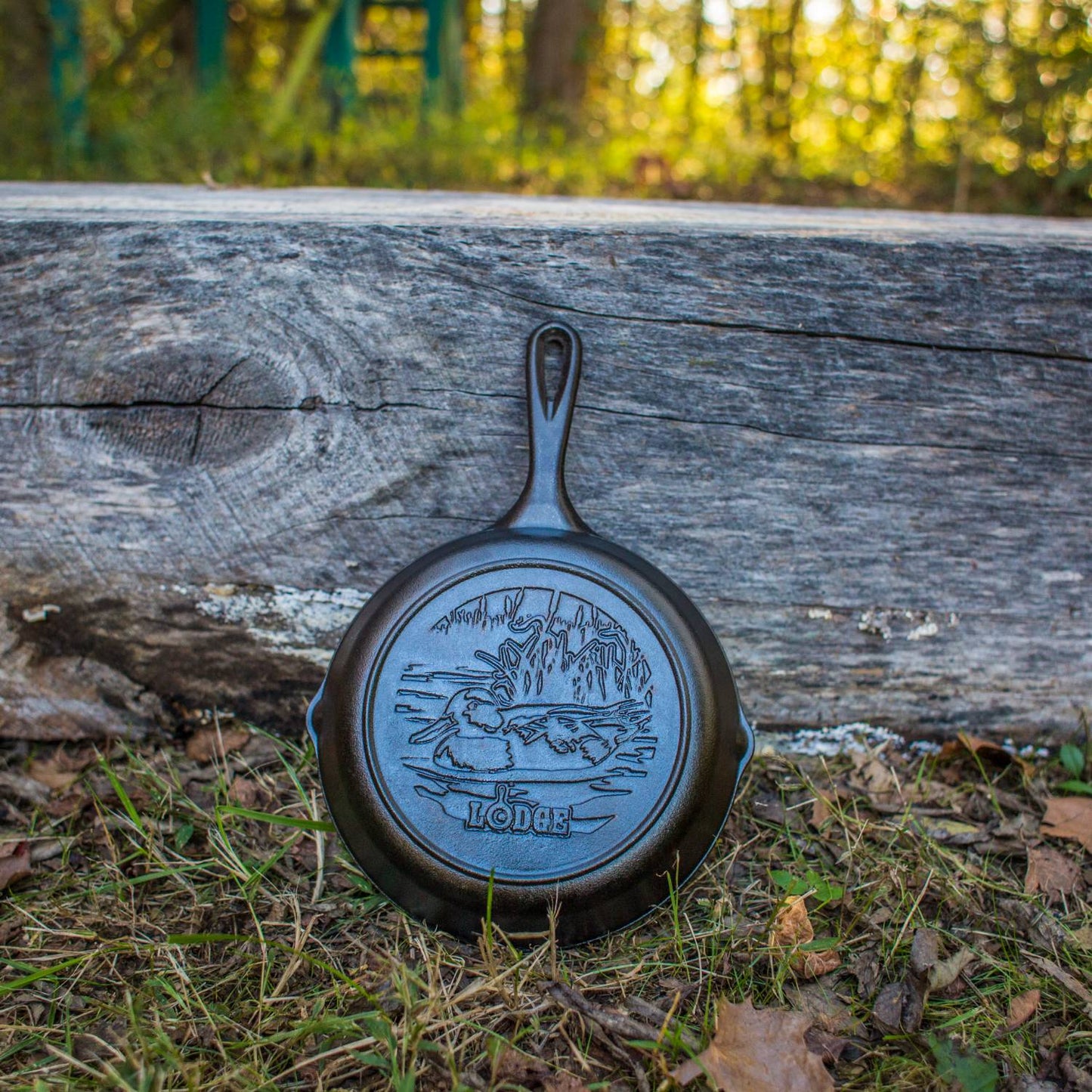 Handcrafted cast iron skillet with an embossed duck design resting outdoors against weathered wood, ideal for Kitchen & Food, Cookware, Cast Iron, USA Made, Best Sellers, and Promo Eligible collections.