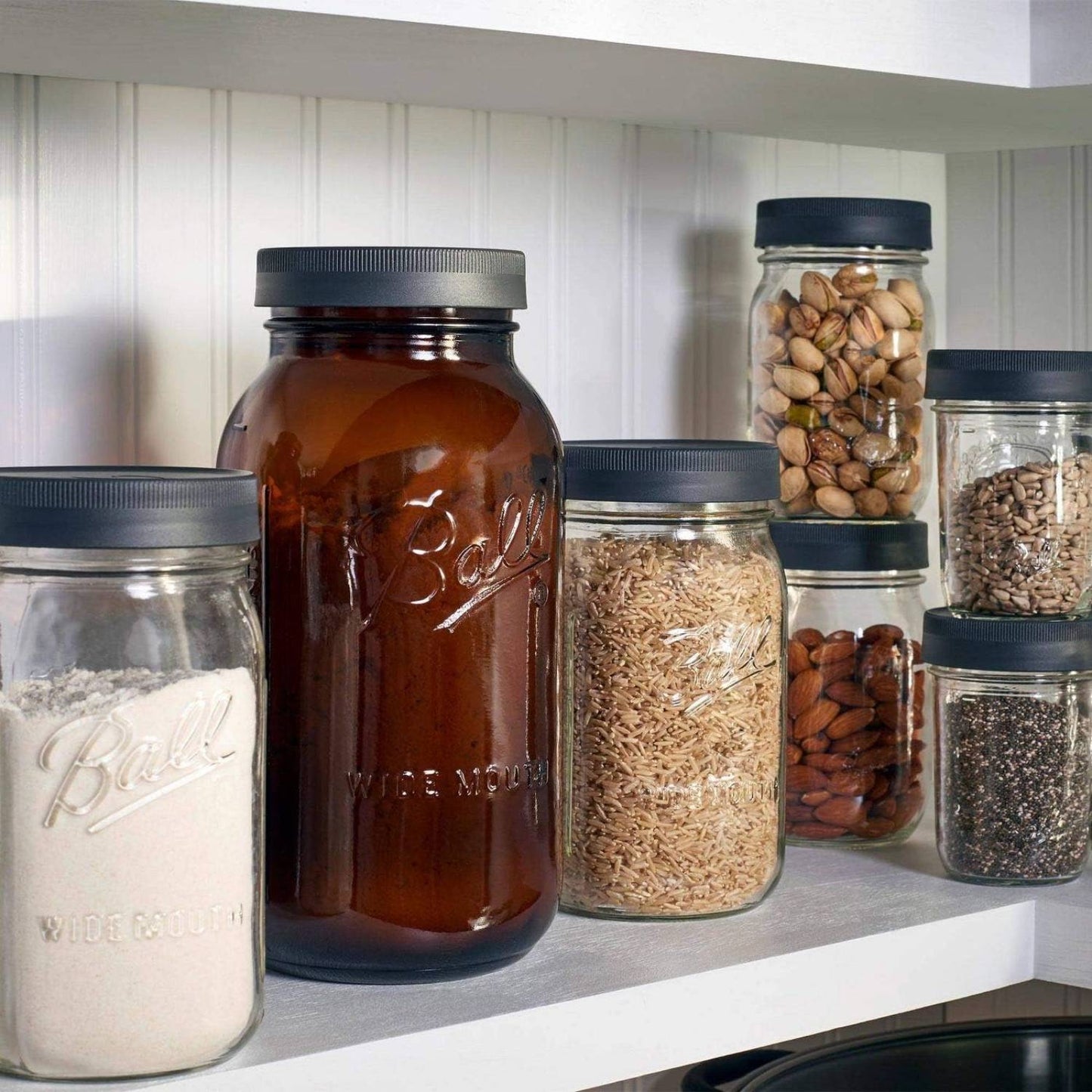 Set of six textured dark lids sealing wide mouth glass jars filled with various pantry staples like flour, rice, nuts, and seeds, ideal for Kitchen & Food, Storage and Serving, Best Sellers, and Promo Eligible collections.