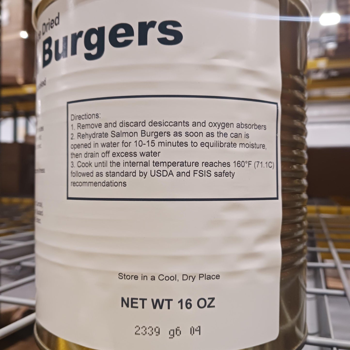 Close-up of preparation instructions on a freeze-dried salmon burger can, emphasizing safe rehydration and cooking guidelines, part of USA Made Kitchen & Food and Emergency Supplies collections.