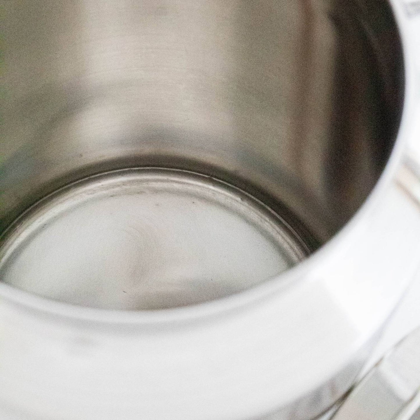 Interior close-up of a seamless small stainless steel milk can made from shining 304 grade metal, designed for easy cleaning and durability in farm, garden, and animal care use.