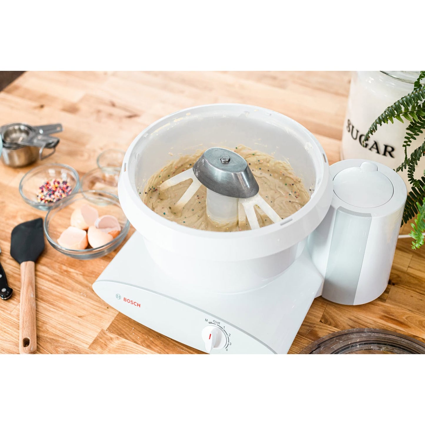 White mixer bowl with cake batter being mixed by lightweight paddle attachments designed for Bosch or NutriMill mixers, handcrafted in the USA for Kitchen & Food and Baking Supplies collections.