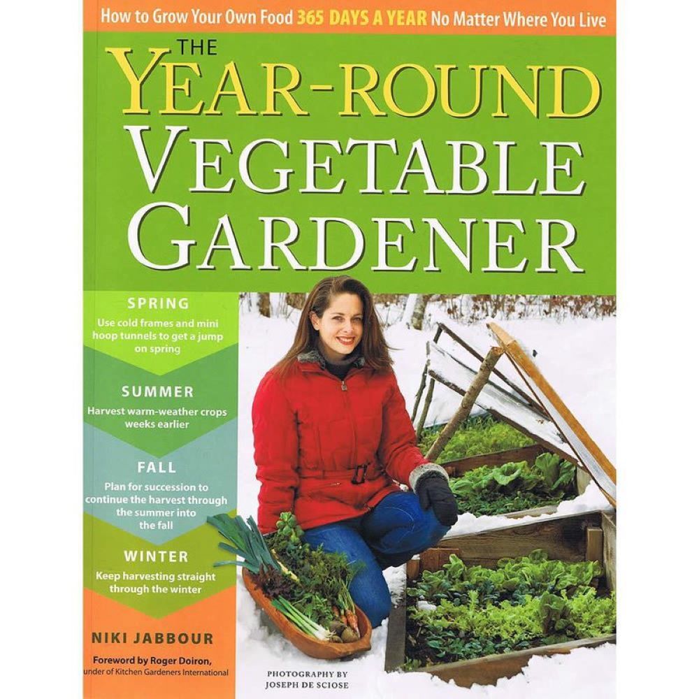 Cover of a year-round vegetable gardening book featuring a woman harvesting fresh greens from a handcrafted cold frame, promoting seasonal growing tips in home and garden how-to books.