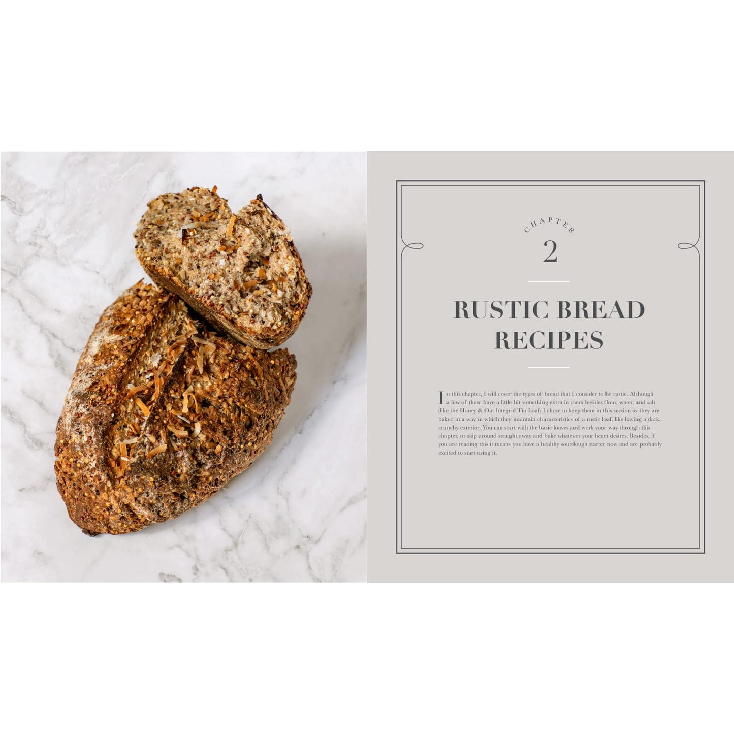 Rustic loaf of multigrain bread with seeds and nuts sliced open next to an open cookbook page titled "Rustic Bread Recipes," suitable for Books, Cookbooks, and Home and Garden How-To Books collections.
