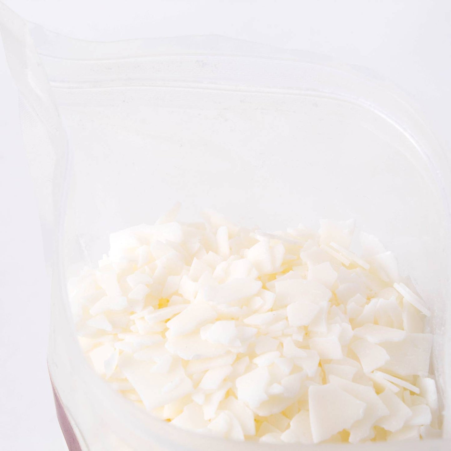 Close-up of handcrafted all-natural white soy wax pellets in a clear resealable bag, featured in Lamps & Lighting, Candles and Candlemaking, Candlemaking Supplies, Best Sellers, and Promo Eligible collections.