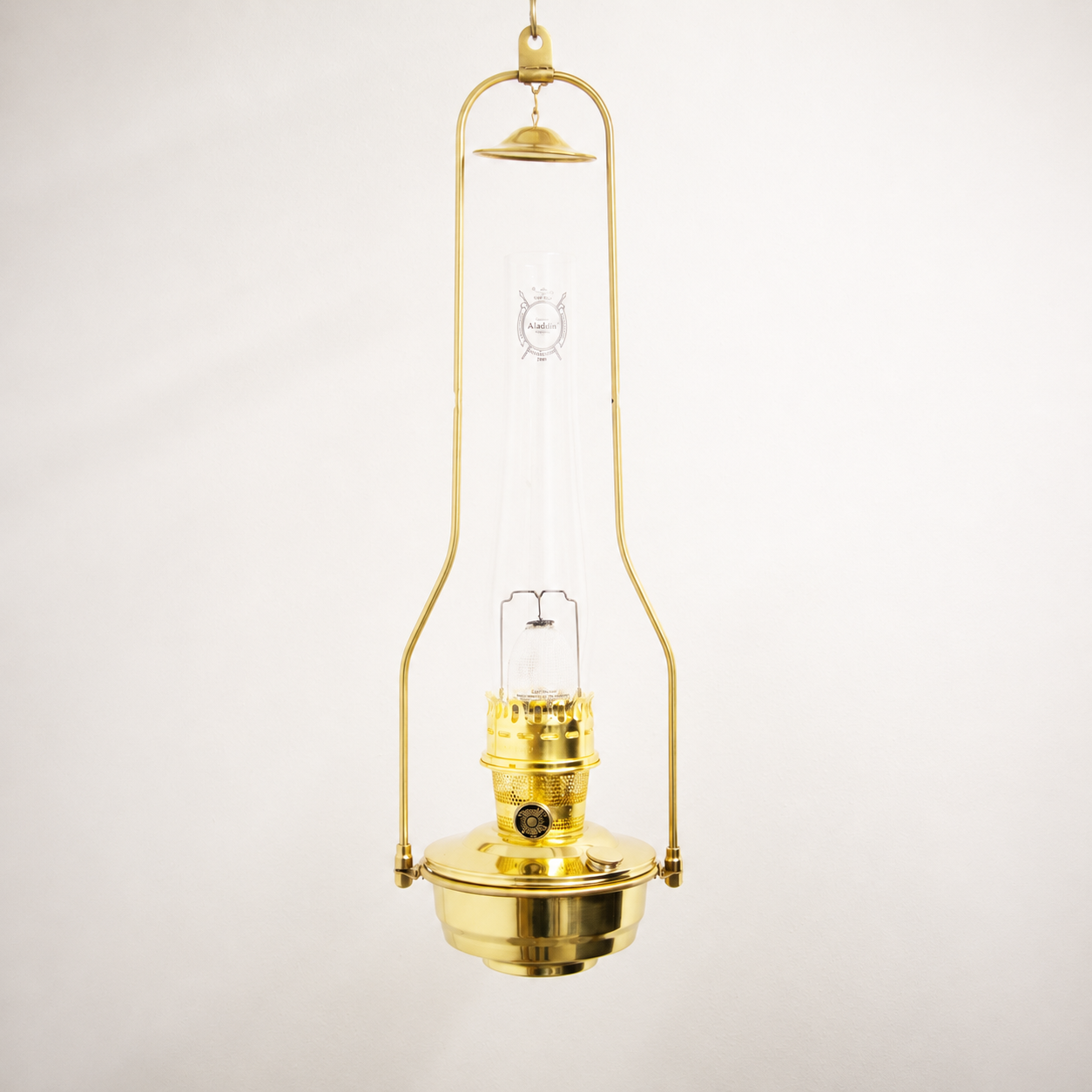 Polished brass hanging bracket with tilt-frame design holding a classic oil lamp with clear glass chimney, ideal for Lamps & Lighting, Oil Lamps, and Hanging Lamps collections.