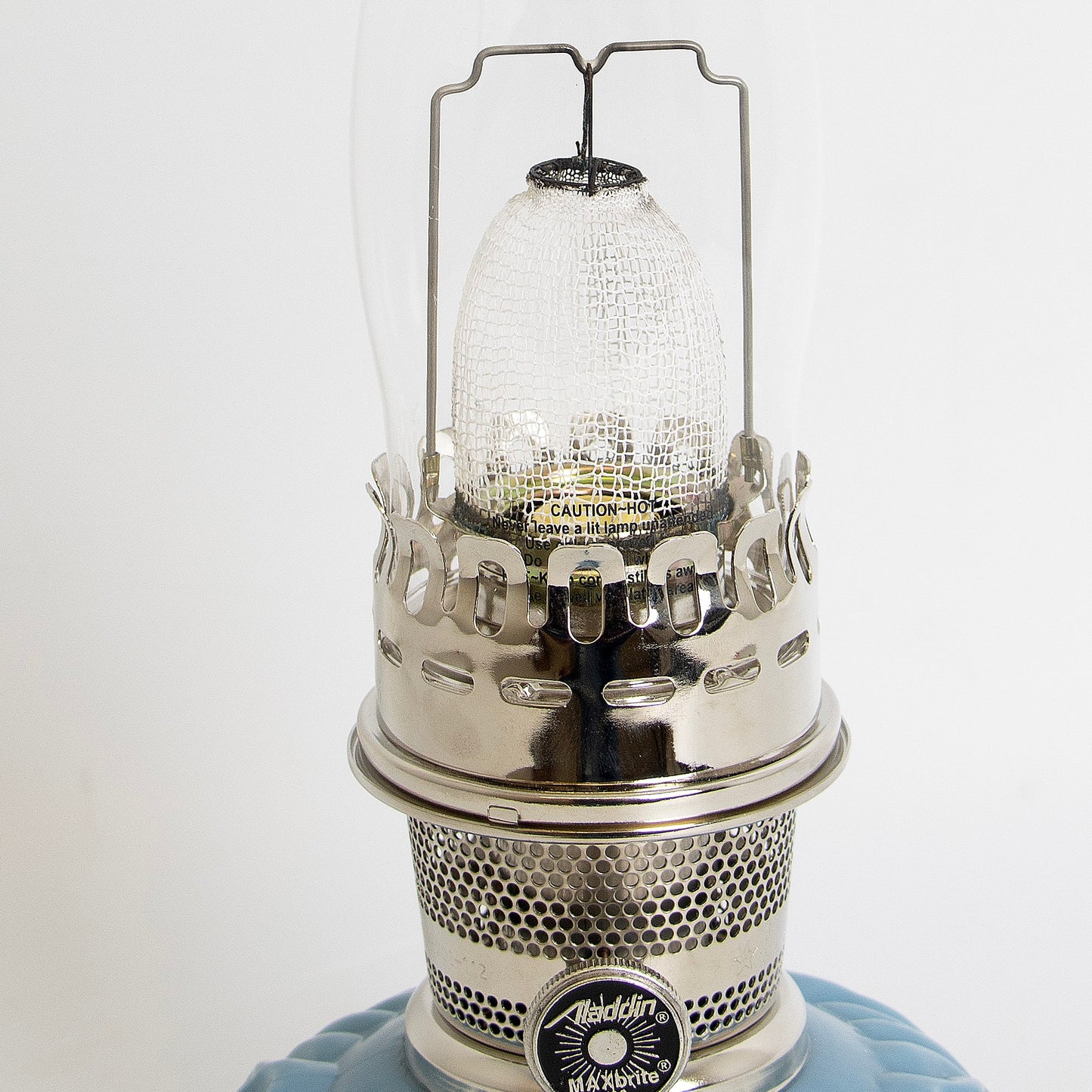 Close-up of a unique handcrafted brass burner with perforated design and clear textured glass chimney on a limited edition blue glass base oil lamp, featured in Lamps & Lighting, Oil Lamps, Table Lamps, Best Sellers, and Promo Eligible collections.