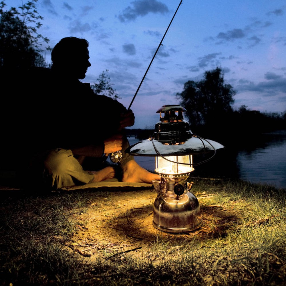 Petromax pressure lamp equipped with a polished reflector casting focused warm light downward near a person fishing at dusk, featured in Lamps & Lighting, Parts and Accessories, Other Parts, Best Sellers, and Promo Eligible collections.