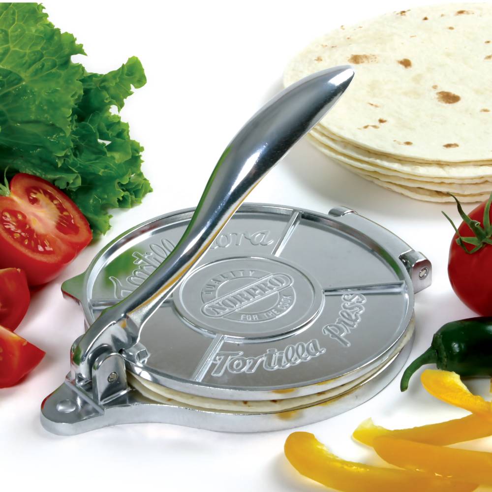 Cast aluminum tortilla press with a smooth handle for even dough pressing, surrounded by fresh vegetables and stacked tortillas, ideal for Kitchen & Food, Cookware, Baking Supplies, Best Sellers, and Promo Eligible collections.