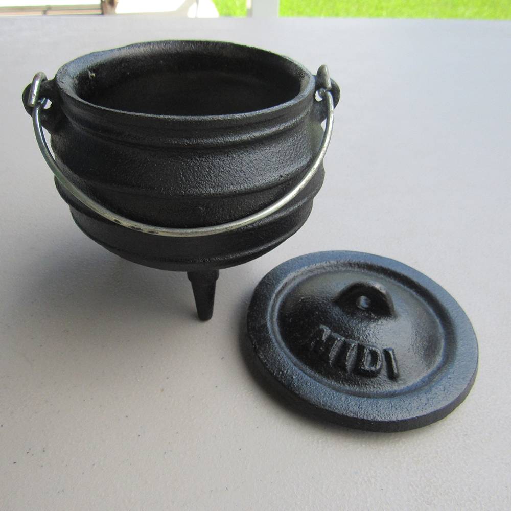 Small cast iron pot with three built-in legs and a detachable lid stamped "Midi," featuring a metal handle, ideal for outdoor dining, part of Kitchen & Food and Cast Iron collections.