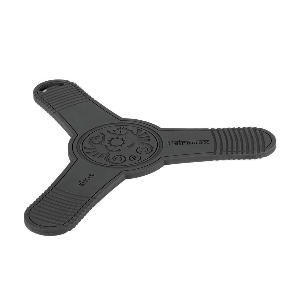 Black silicone trivet with three textured arms and decorative center, designed as a sturdy non-slip base for hot Dutch oven lids and pans in Farm, Garden & Tool and Kitchen & Food collections.