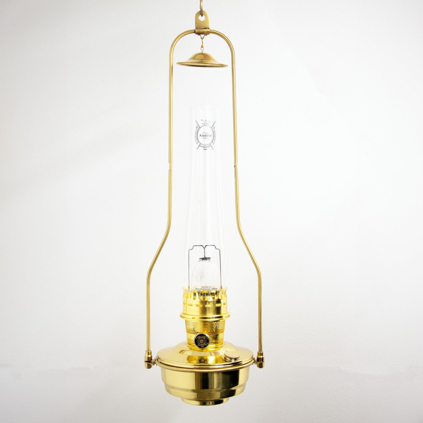 Brass hanging oil lamp with clear glass chimney, designed for farm, garden, and emergency lighting, handcrafted for durable and bright illumination in rustic settings.