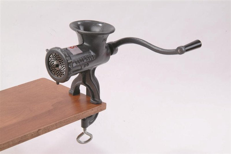 Heavy-duty metal clamp-down meat grinder with a curved hand crank attached to a wooden surface, ideal for Kitchen & Food, Specialty Equipment, Butchering Supplies, USA Made, Best Sellers, and Promo Eligible collections.