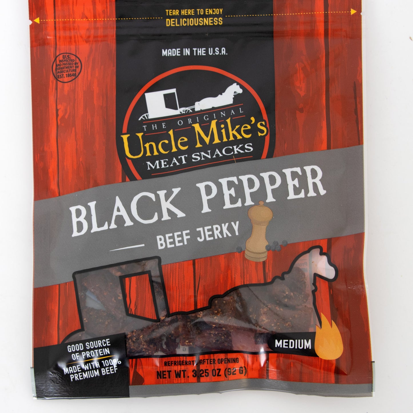 Resealable bag of medium-spiced black pepper beef jerky in red and black packaging with clear window showing dark, handcrafted, protein-rich snack made in USA for Kitchen & Food, Snacks and Sweets, Meats, USA Made, Best Sellers, and Promo Eligible collections.