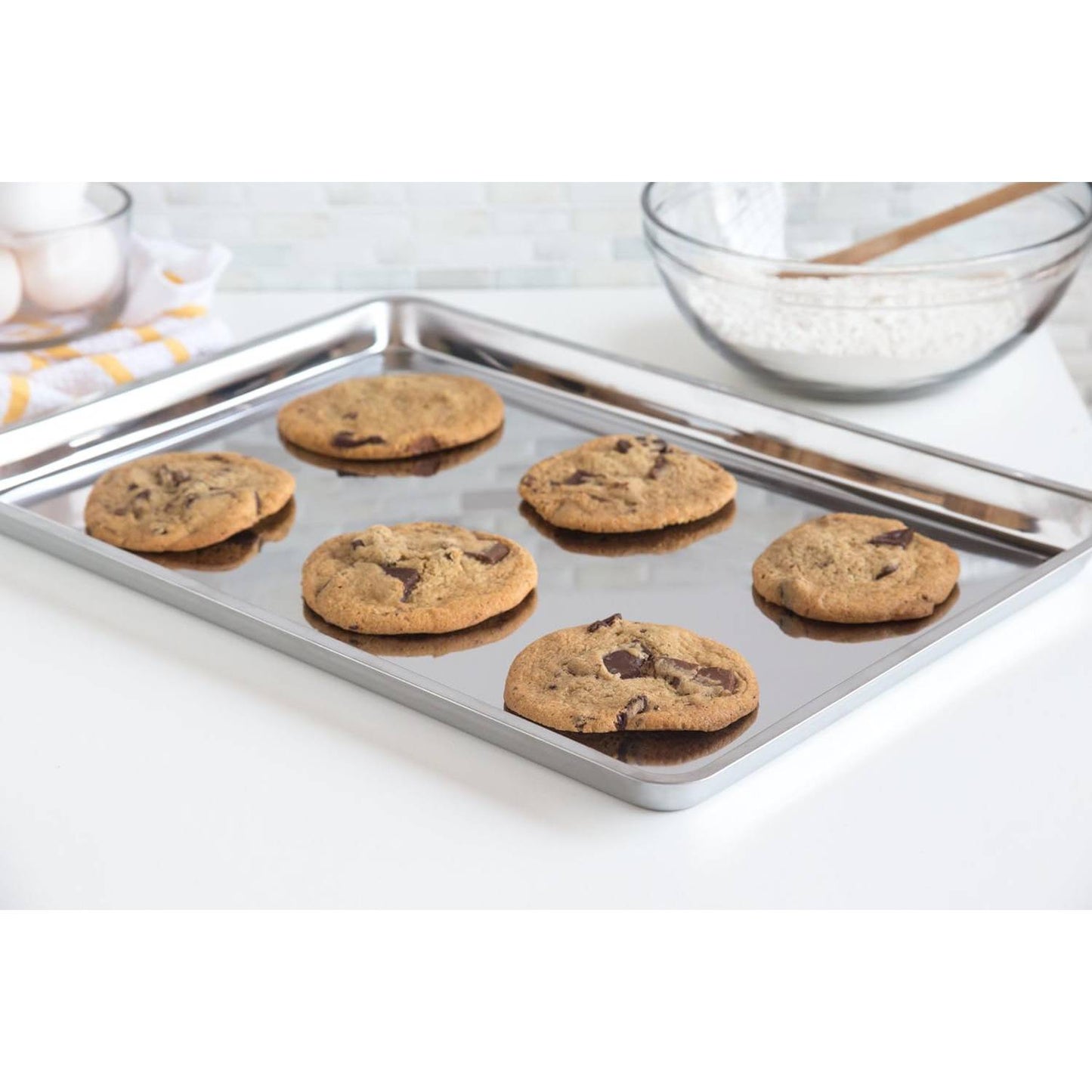 Stainless steel all-purpose jelly roll pan with a smooth, scratch-resistant surface holding freshly baked chocolate chip cookies, ideal for Kitchen & Food, Baking Supplies, and Cookware collections.
