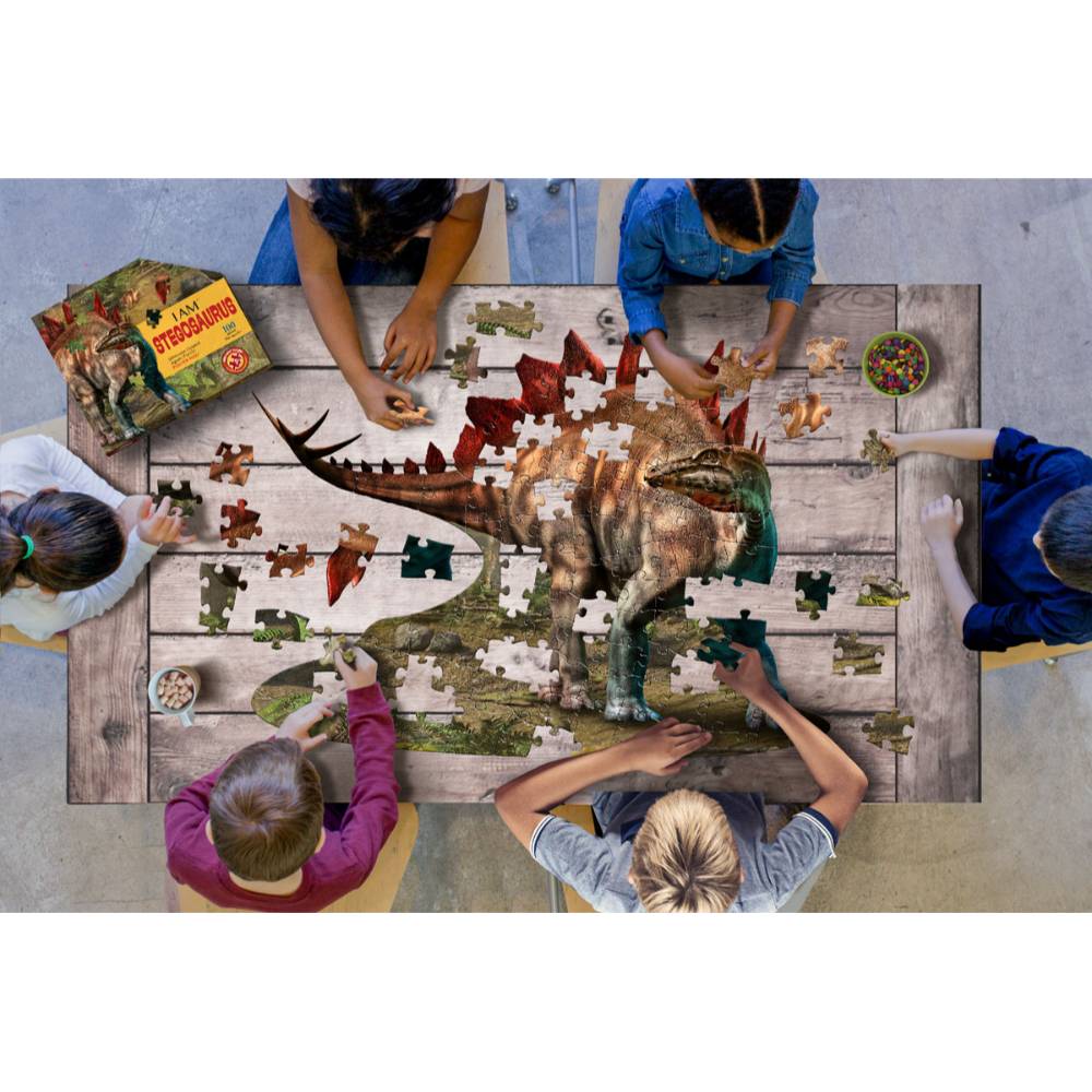 Children gathered around a wooden table assembling a uniquely shaped 100-piece Stegosaurus jigsaw puzzle, featuring large pieces perfect for small hands, part of Toys, Books & Games and Children's Toys collections.
