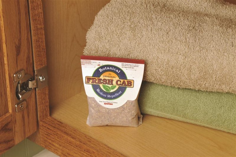 Small pouch of handcrafted Fresh Cab botanical rodent repellent with pungent balsam fir scent, placed on wooden cabinet shelf near folded towels, ideal for Farm, Garden & Tool and Pest Control.