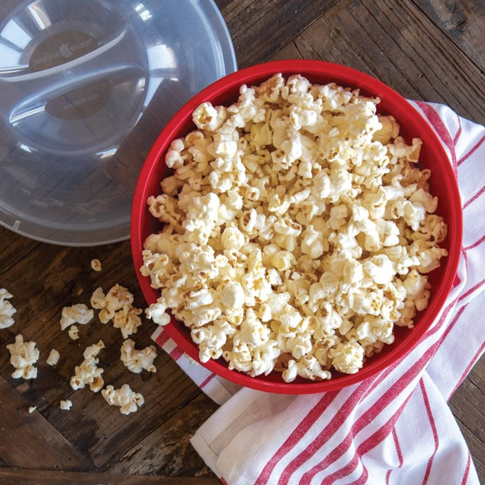 Red BPA-free microwavable bowl filled with freshly popped popcorn, accompanied by a clear vented lid and striped kitchen towel, ideal for Kitchen & Food, Popcorn, and Cooking and Baking Helpers collections.