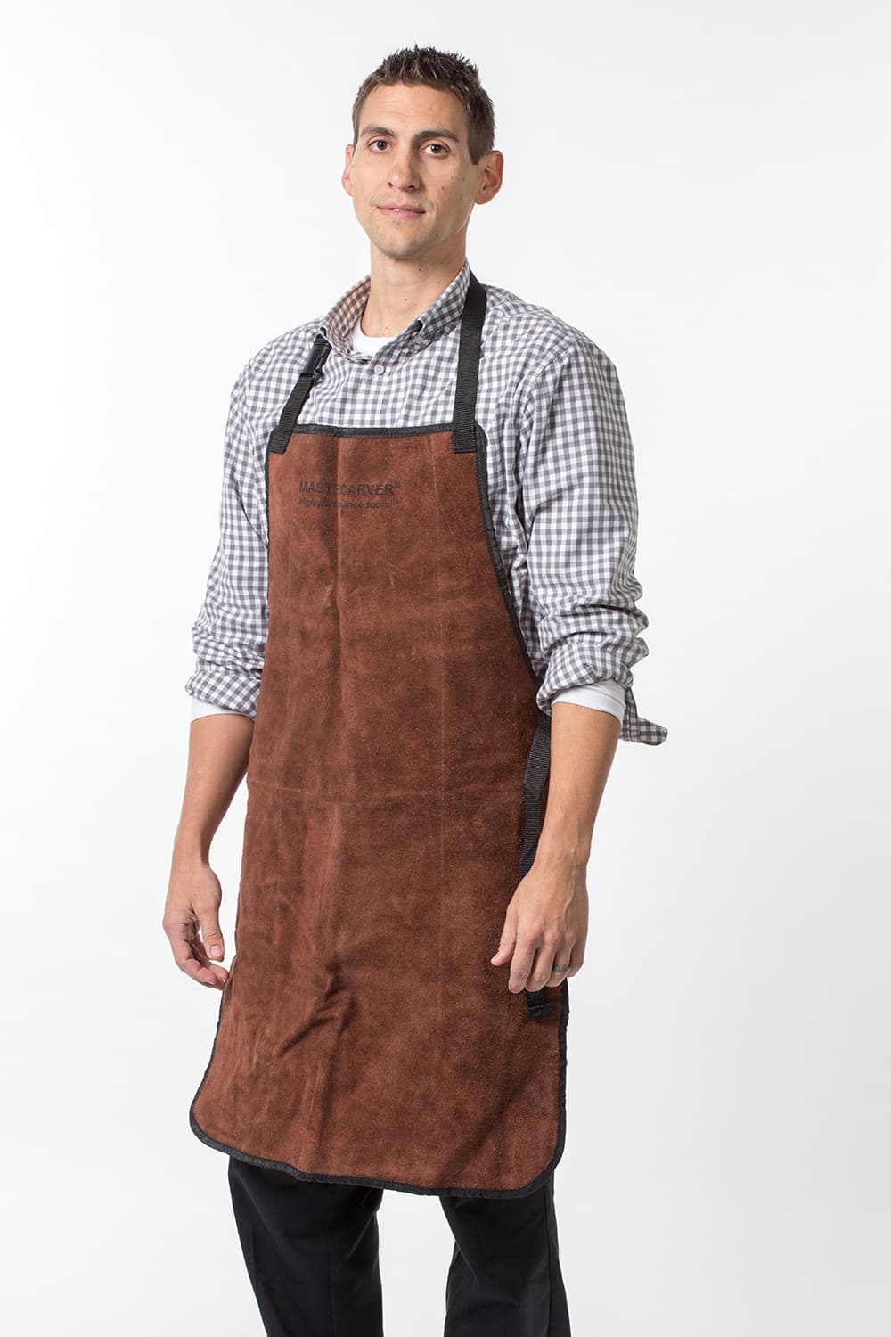 Man wearing a handcrafted natural leather apron with suede finish, steel rivet reinforcements, and adjustable straps, suitable for carving and woodcutting tasks in Health & Wellness and Farm, Garden & Tool collections.