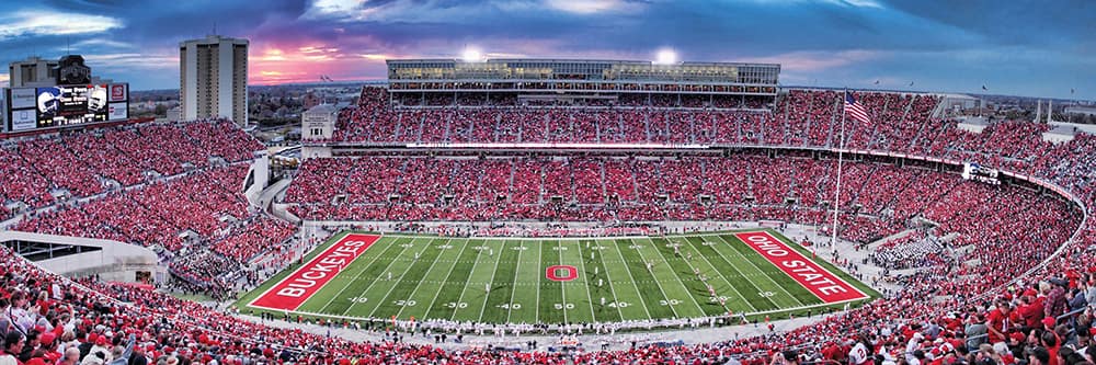 Panoramic view of a packed football stadium with fans dressed in red during sunset, captured from the skybox seat, featured in Toys, Books & Games and Best Sellers collections.