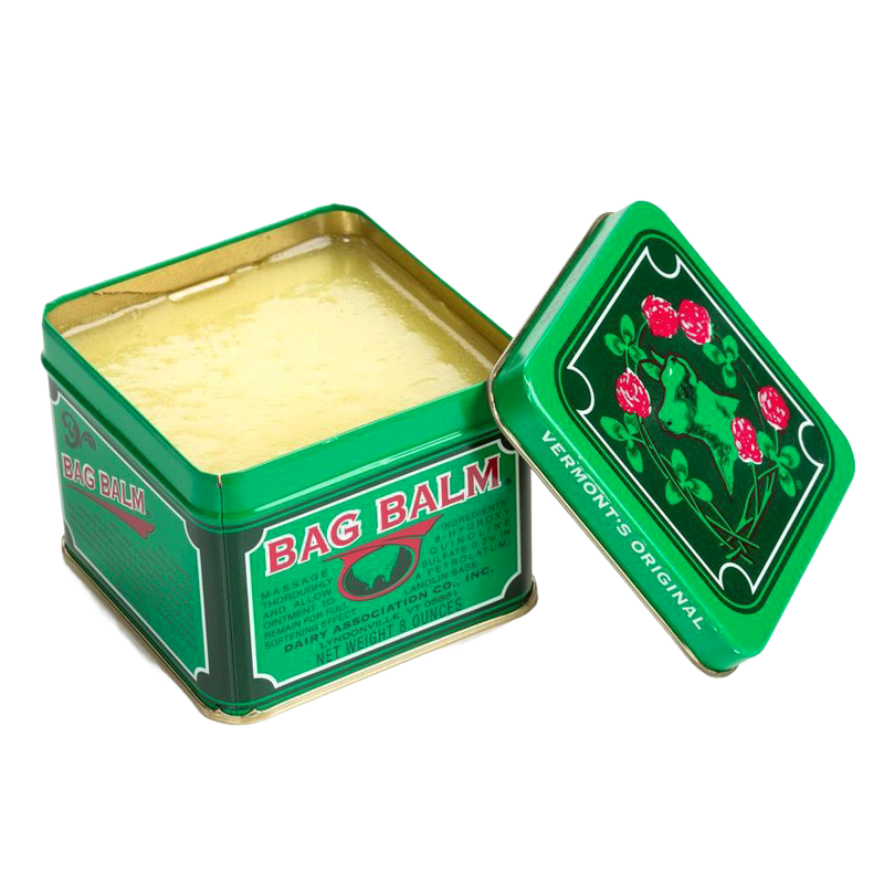 Open green metal tin of Bag Balm with creamy yellow balm inside, featuring vintage-style labeling with red flowers and leaf design, ideal for Health & Wellness and USA Made collections