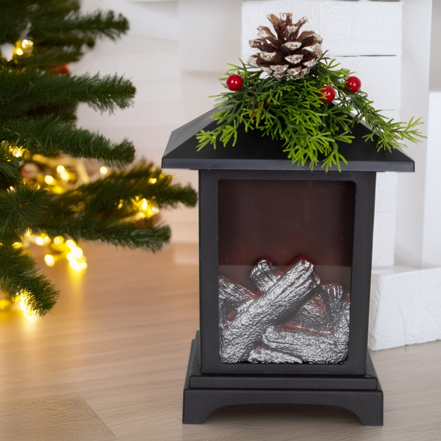 Handcrafted metal LED lantern featuring silver faux fireplace logs inside, topped with festive faux pine sprigs, red berries, and a pinecone, ideal for Home & Decor, Holiday Decor, and Emergency Supplies collections.