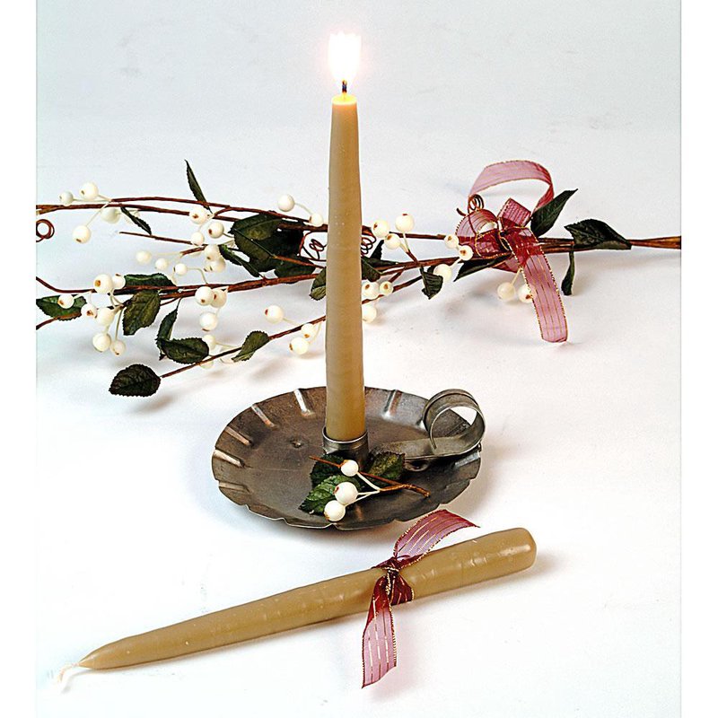 Handcrafted olive-colored bayberry taper candle burning in a rustic metal holder with decorative white berries and greenery, ideal for holiday decor and made in USA.