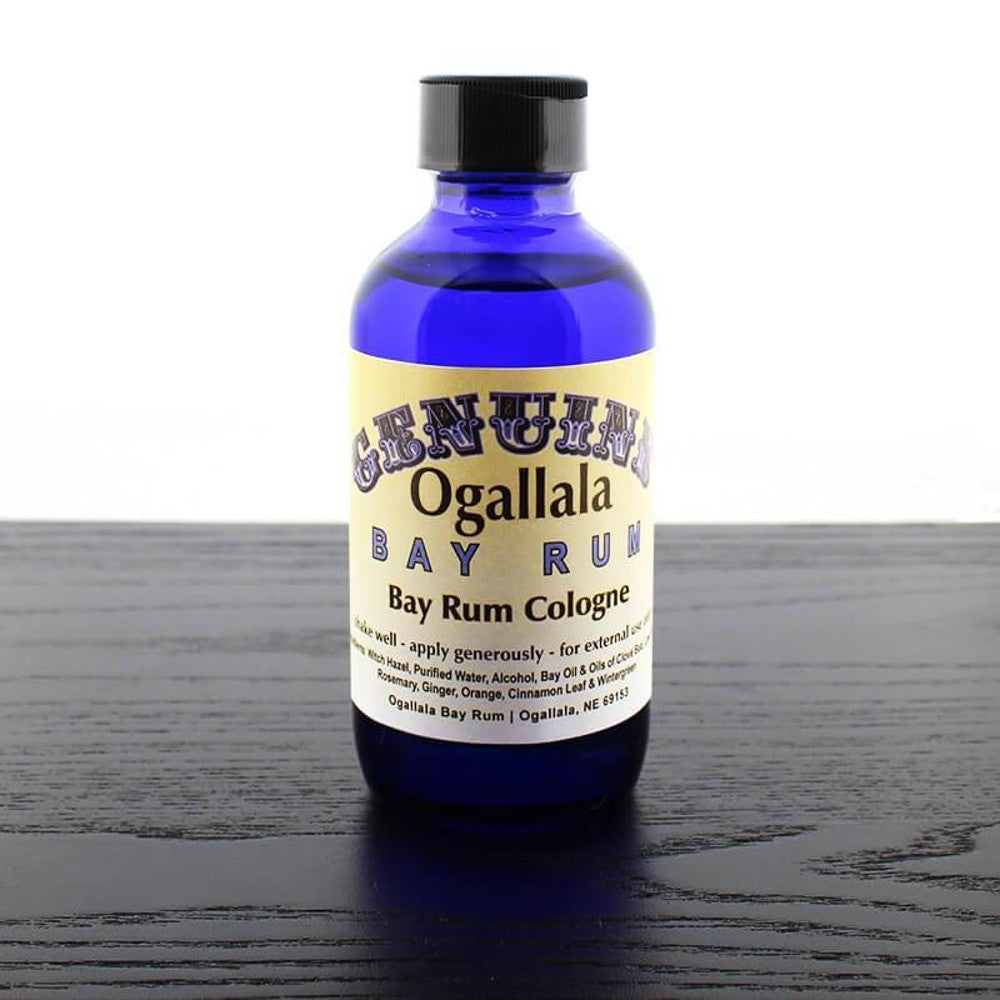Blue glass bottle of handcrafted cologne made in USA with black cap and beige label featuring vintage-style text, part of Health & Wellness and Grooming collections.