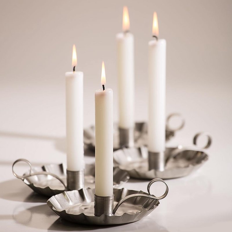 Two pairs of tall white handcrafted candles with thick wicks burning steadily in vintage-style metal candle holders, featured in Lamps & Lighting and Emergency Supplies collections.