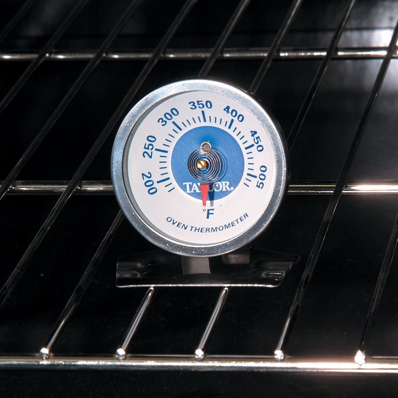 Aluminum oven thermometer with clear temperature dial in Fahrenheit, designed to hang or stand upright, ideal for monitoring heat in kitchen, stoves, cookware, and baking supplies collections.