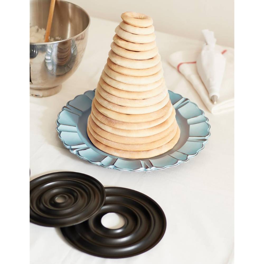 Stacked graduated ring cake layers arranged in a tall tower on a decorative plate, displayed with steel ring molds for making a traditional Norwegian wedding cake, perfect for Kitchen & Food, Cookware, Baking Supplies, Pots and Pans, Best Sellers, and Promo Eligible collections.