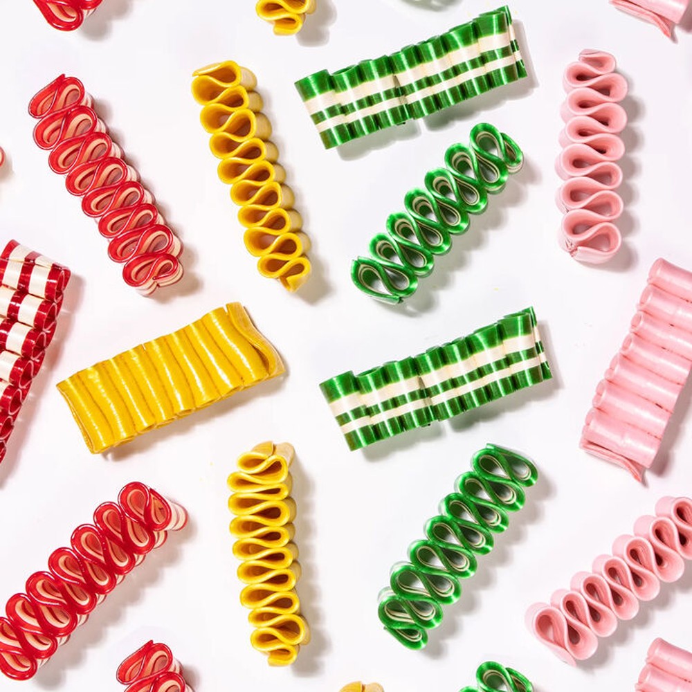 Assorted handspun ribbon candy in vibrant red, yellow, green, and pink hues with distinct stripes, handcrafted in the USA, ideal for Kitchen & Food, Snacks and Sweets collections.