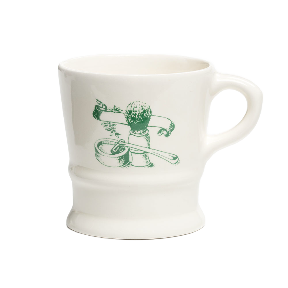 White porcelain shaving mug with vintage-style green illustration of shaving brush, soap, and straight razor, featured in Health & Wellness, Grooming and Personal Hygiene collections.