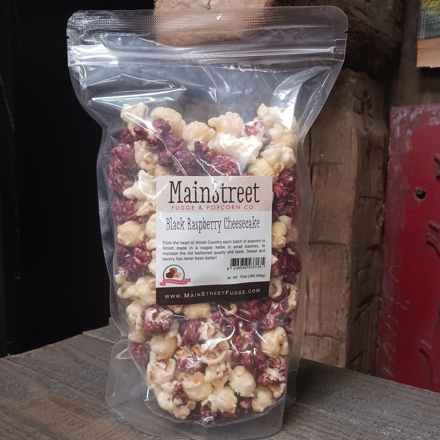Clear resealable bag of handcrafted Amish-made popcorn in black raspberry cheesecake flavor with a mix of white and deep raspberry-coated pieces, featured in Kitchen & Food, Food, Snacks and Sweets, Popcorn, USA Made, Best Sellers, Promo Eligible collections.