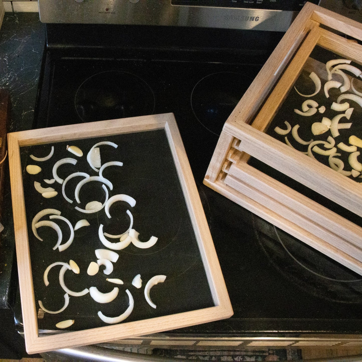 Handcrafted solid oak drying trays with fiberglass screens holding sliced onions, designed for food preservation in Kitchen & Food, Food Preservation, Drying, USA Made, and Best Sellers collections.