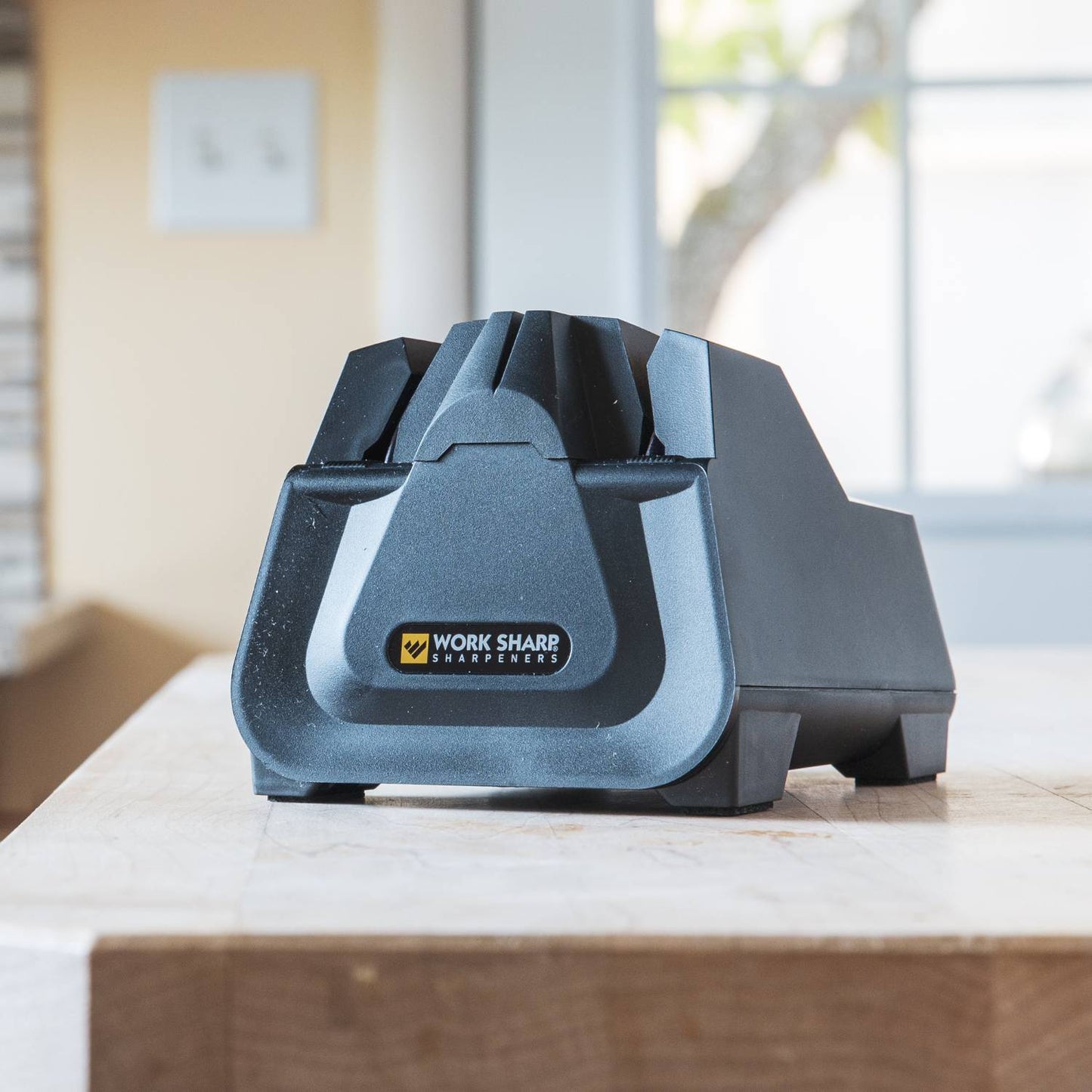 Compact electric kitchen knife sharpener in matte black with angled guides and ergonomic design, perfect for sharpening knives and scissors, featured in Sharpening and Kitchen & Food collections.