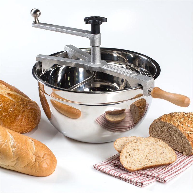 Handcrafted stainless steel bread dough maker with wooden handle resting on a matching mixing bowl, shown alongside freshly baked whole and sliced bread for Kitchen & Food and Baking Supplies collections.