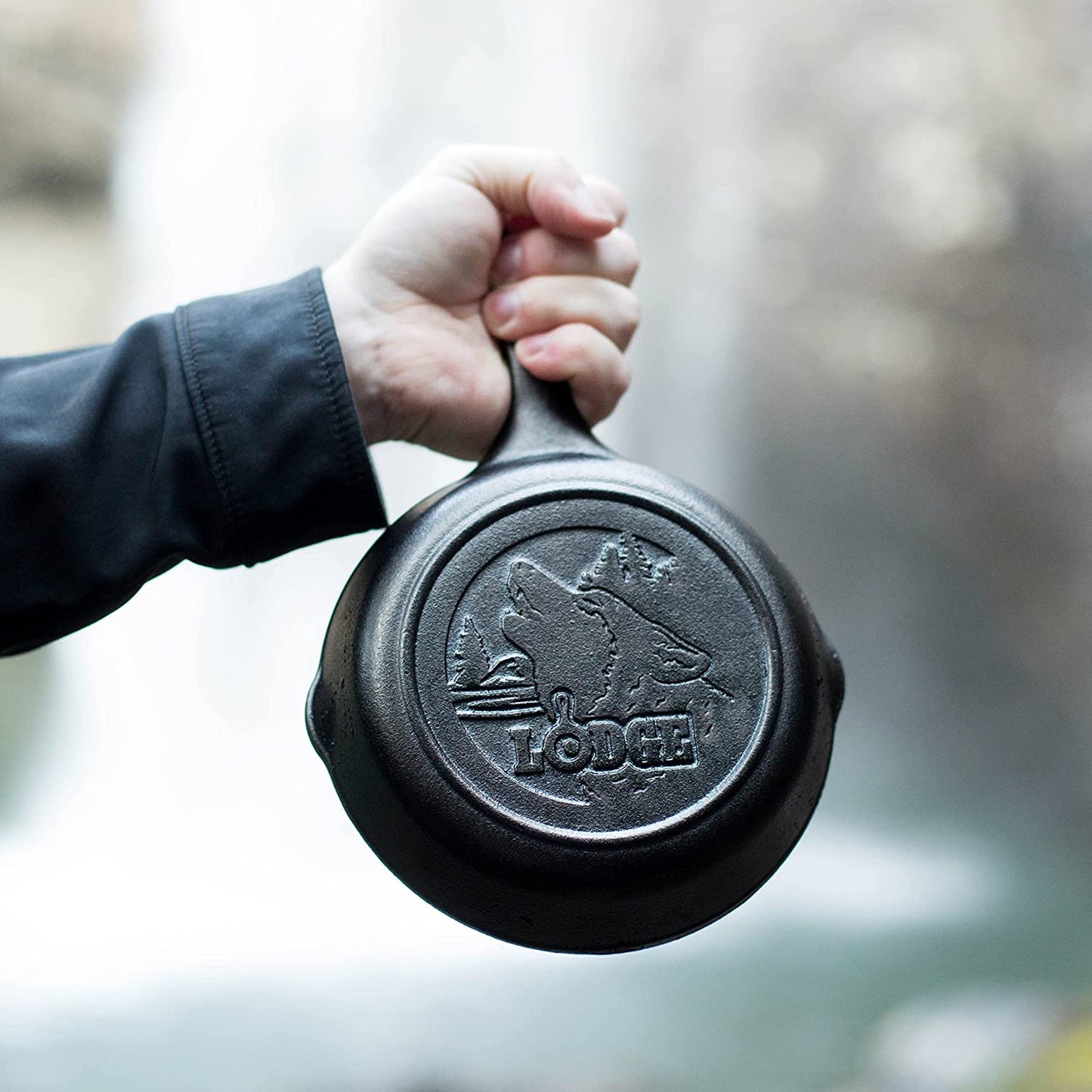Handheld small cast iron skillet featuring a raised howling wolf design and Lodge logo, crafted in the USA for Kitchen & Food, Cookware, Cast Iron, and Best Sellers collections.