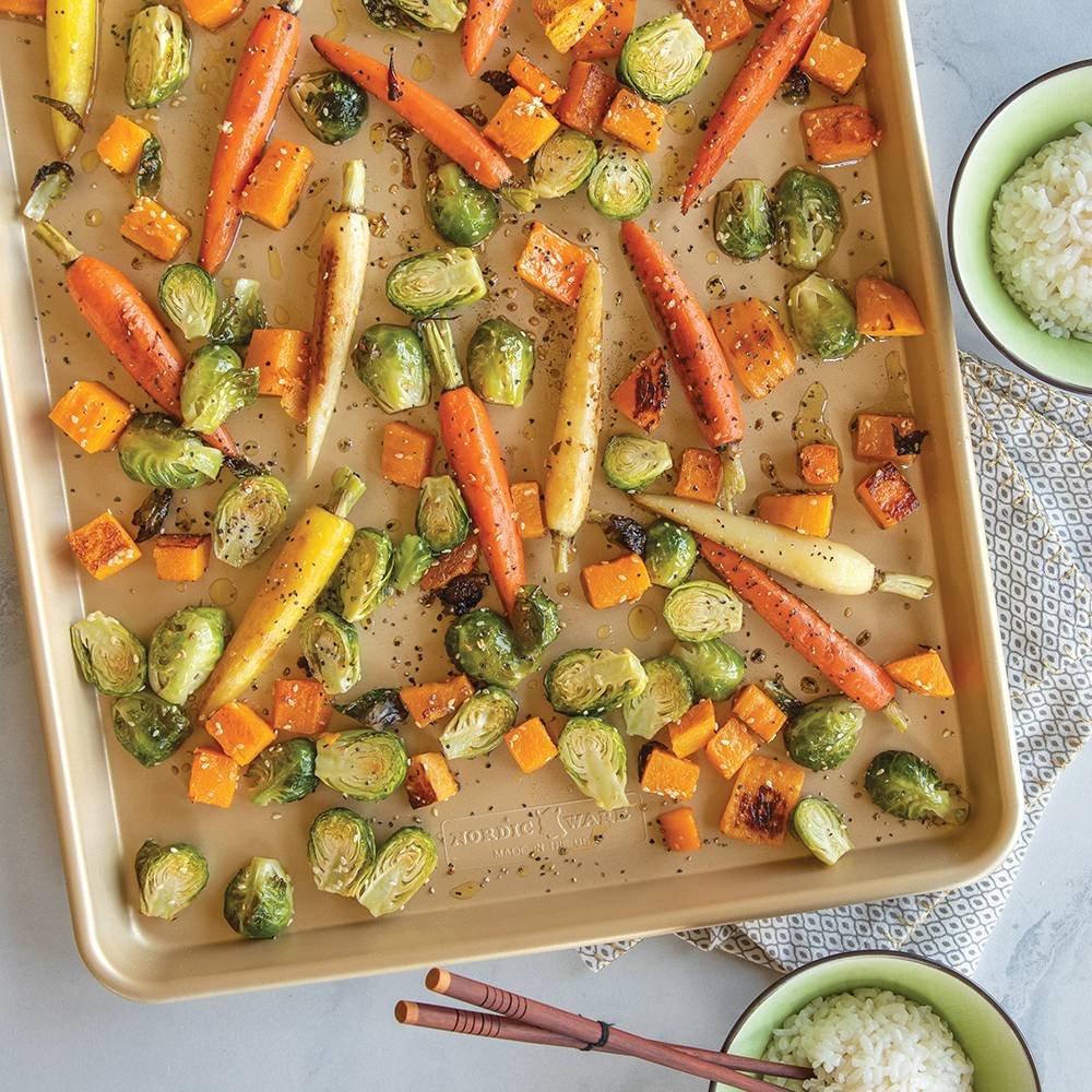 Natural aluminum baking pan with premium gold nonstick surface roasting a colorful mix of carrots, brussels sprouts, and cubed squash, perfect for Kitchen & Food, Cookware, Baking Supplies, USA Made, Best Sellers, and Promo Eligible collections.