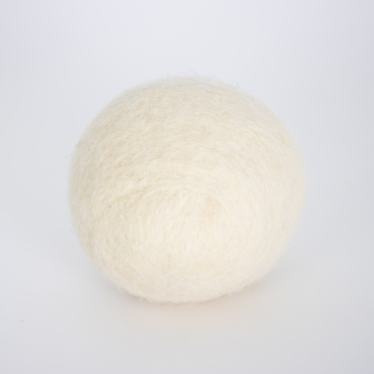 Single natural cream-colored wool dryer ball, handcrafted in the USA for repeated use, featured in Home & Decor and Laundry Supplies collections.