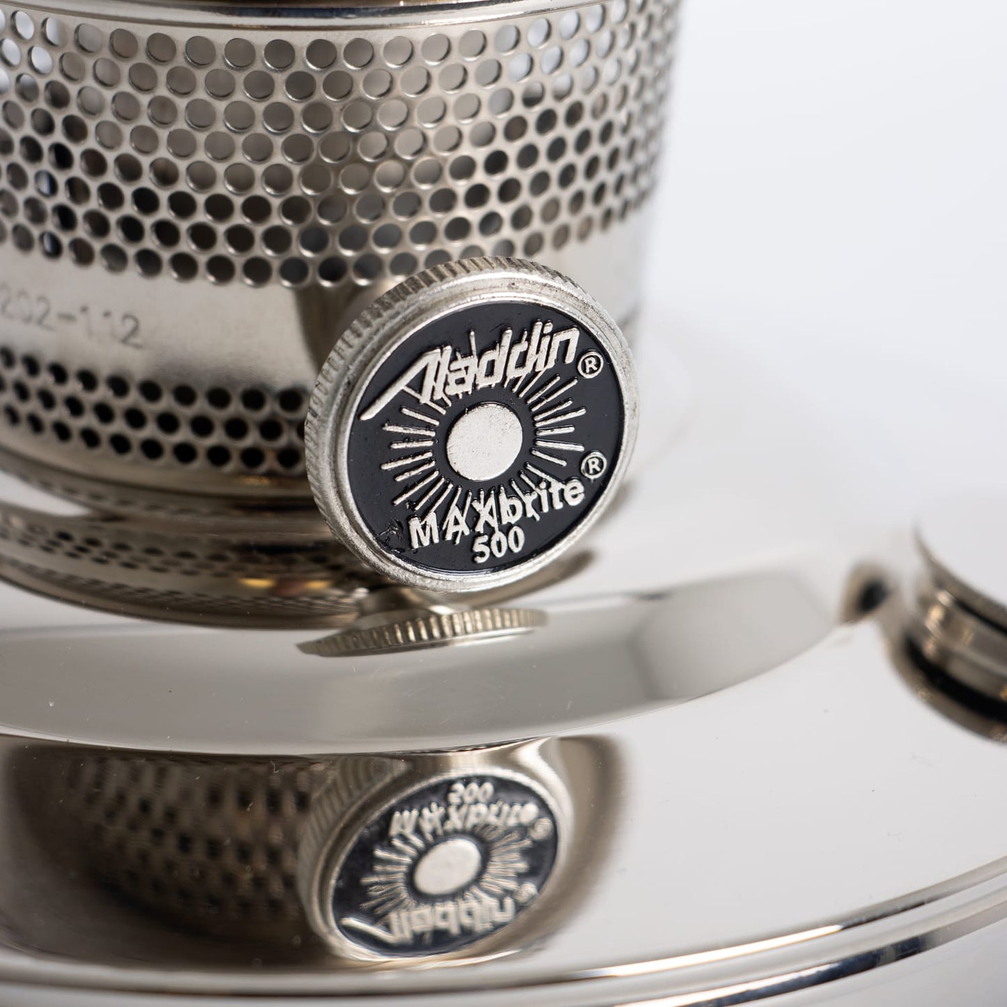 Close-up of the adjustment knob on a handcrafted Aladdin chrome-plated oil lamp burner with perforated metal design, featured in Farm, Garden & Tool, Lamps & Lighting, and Emergency Supplies collections.