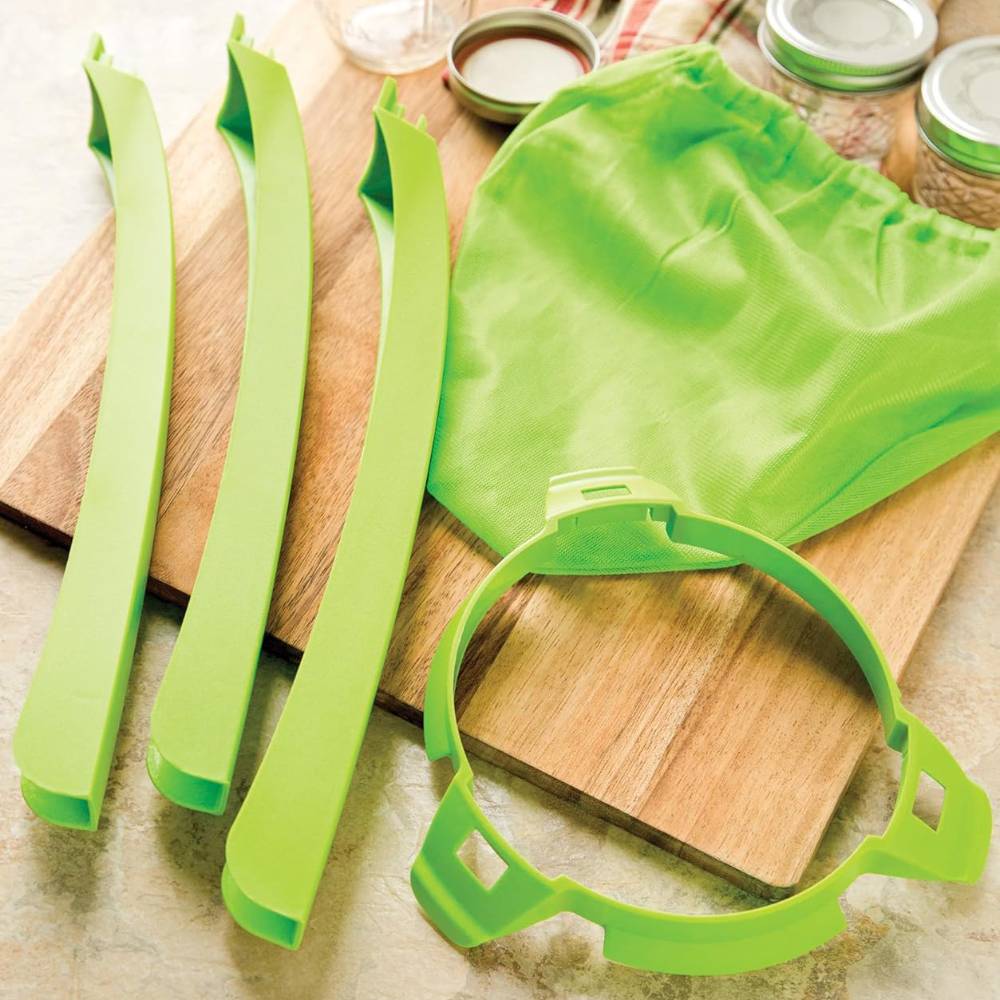 Bright green jelly strainer components including elastic band and frame resting on a wooden board, featured in Kitchen & Food, Food Preservation, and Canning Accessories collections.