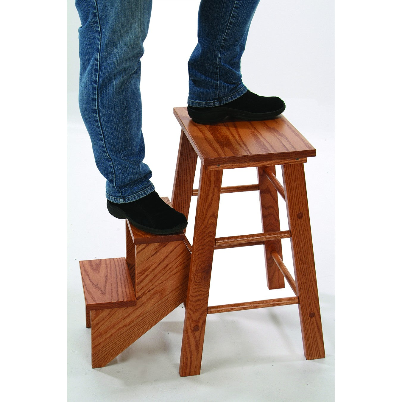 Person wearing black shoes and jeans stepping onto a handcrafted solid oak step stool with smooth lacquered finish, sturdy design, and natural wood grain, ideal for Home & Decor and USA Made collections.