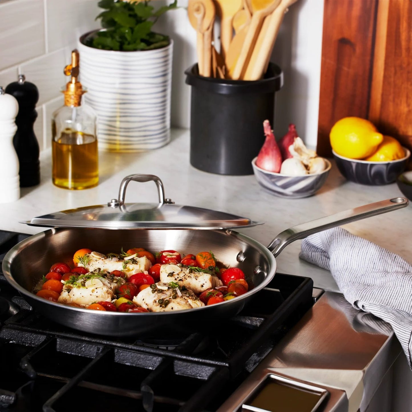 Handcrafted fully clad stainless steel fry pan cooking a savory dish with chicken, cherry tomatoes, and herbs, set on a stovetop with kitchen utensils and fresh ingredients nearby, featured in Kitchen & Food, Cookware, Pots and Pans, Best Sellers, and Promo Eligible collections.