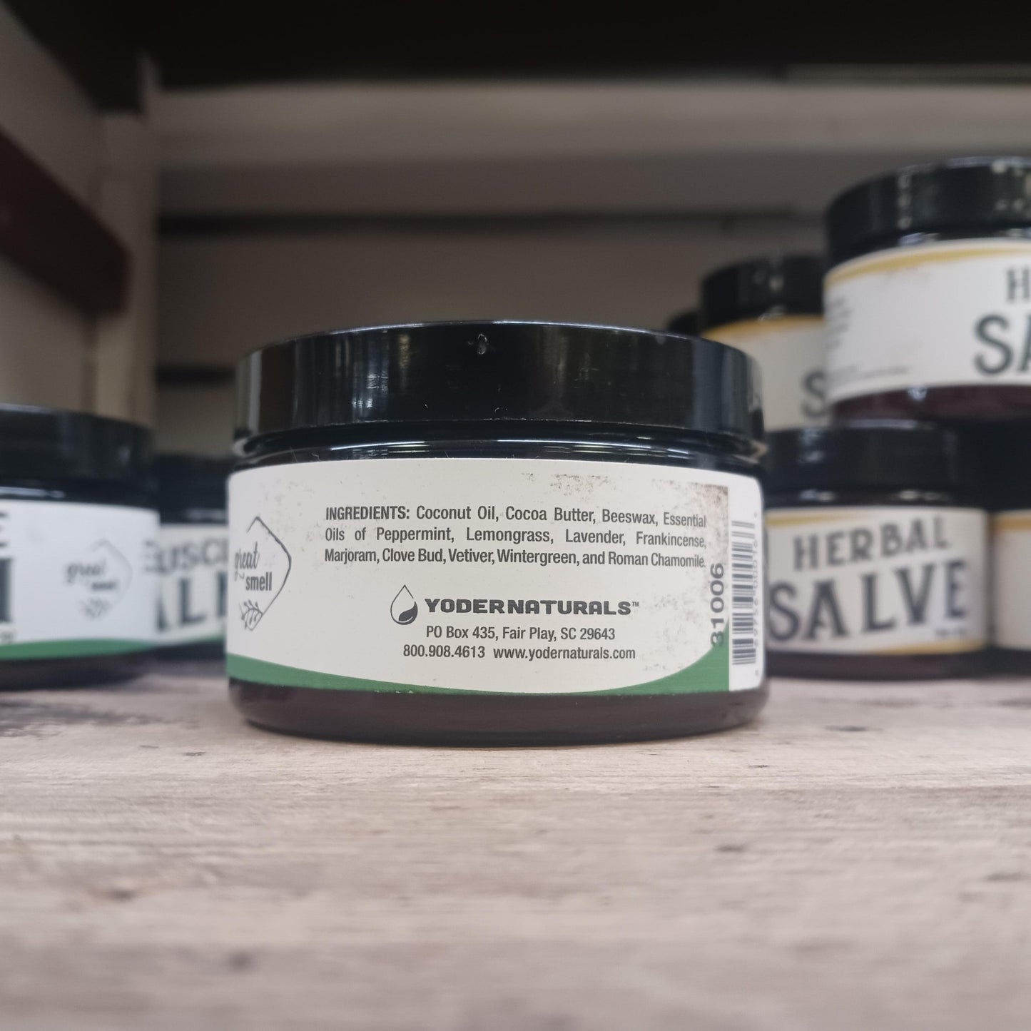 Small black jar of natural muscle balm with a white label listing coconut oil, cocoa butter, beeswax, and essential oils, part of Health & Wellness, Balms, Creams and Lotions, USA Made, and Best Sellers collections.