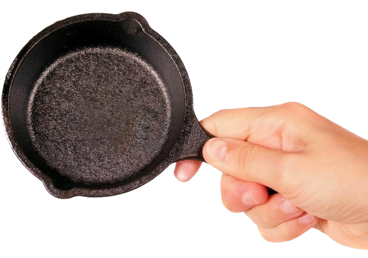 Hand holding a pre-seasoned mini cast iron skillet with textured cooking surface and small handle, ideal for kitchen gadgets and cast iron cookware collections.
